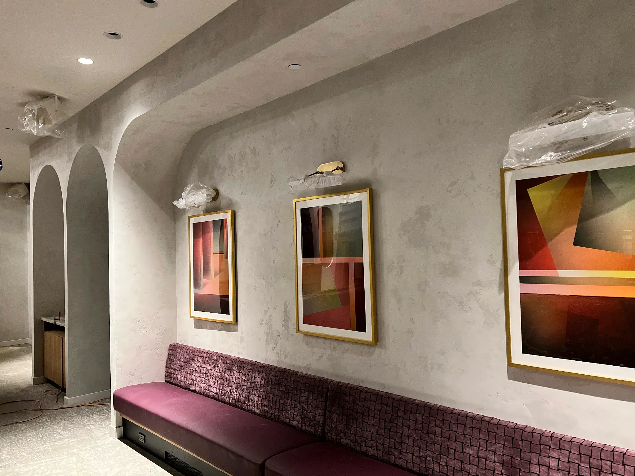 Moxy Hotel Williamsburg — plaster gallery corridor with arched openings and banquette seating