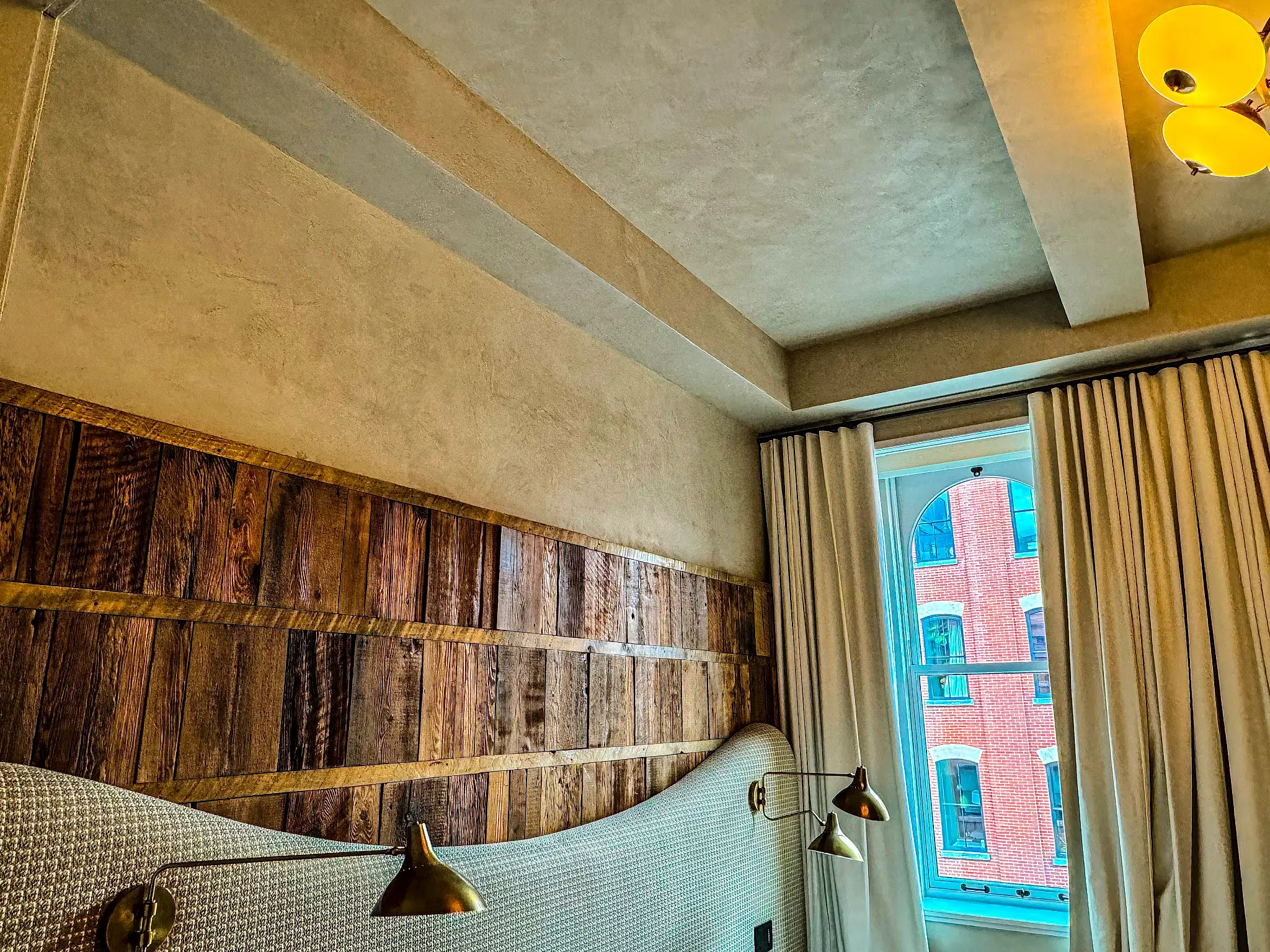 Laight St Residence — detail of the lime-plaster beam meeting the reclaimed wood headboard wall