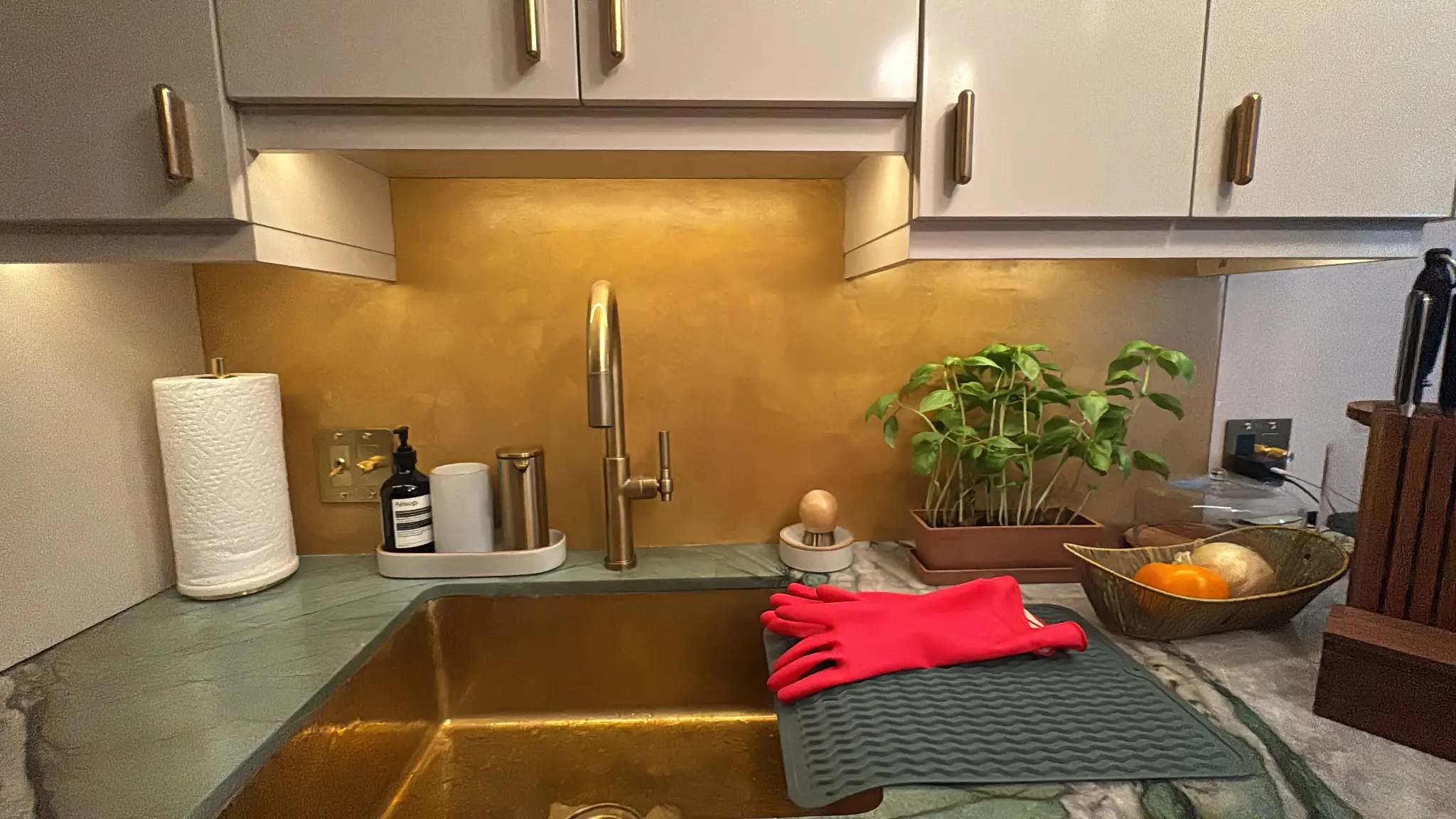 Horatio St. Apartment — kitchen sink wall with gold polished-plaster backsplash