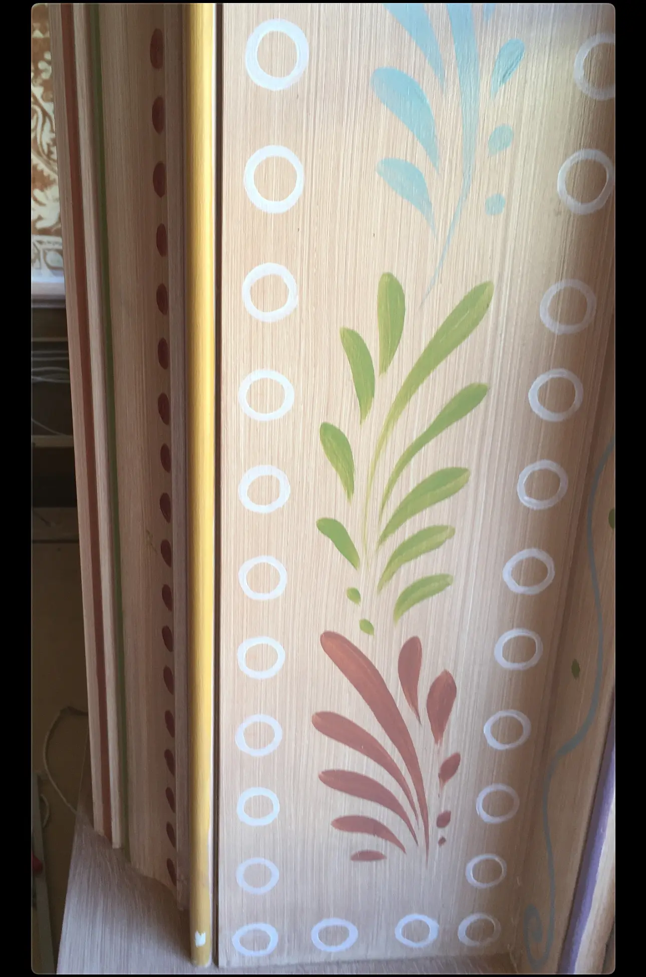 Maxime's — hand-painted leaf and ring motif over a faux wood-grain pilaster